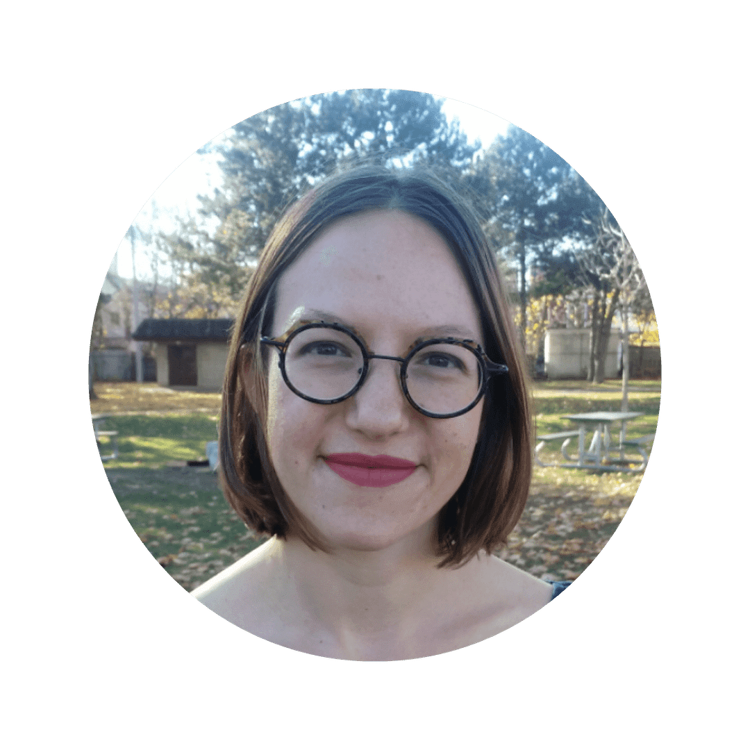 Melanie Wilmink, a white woman with short brown hair, smiles at the camera. She is wearing glasses.